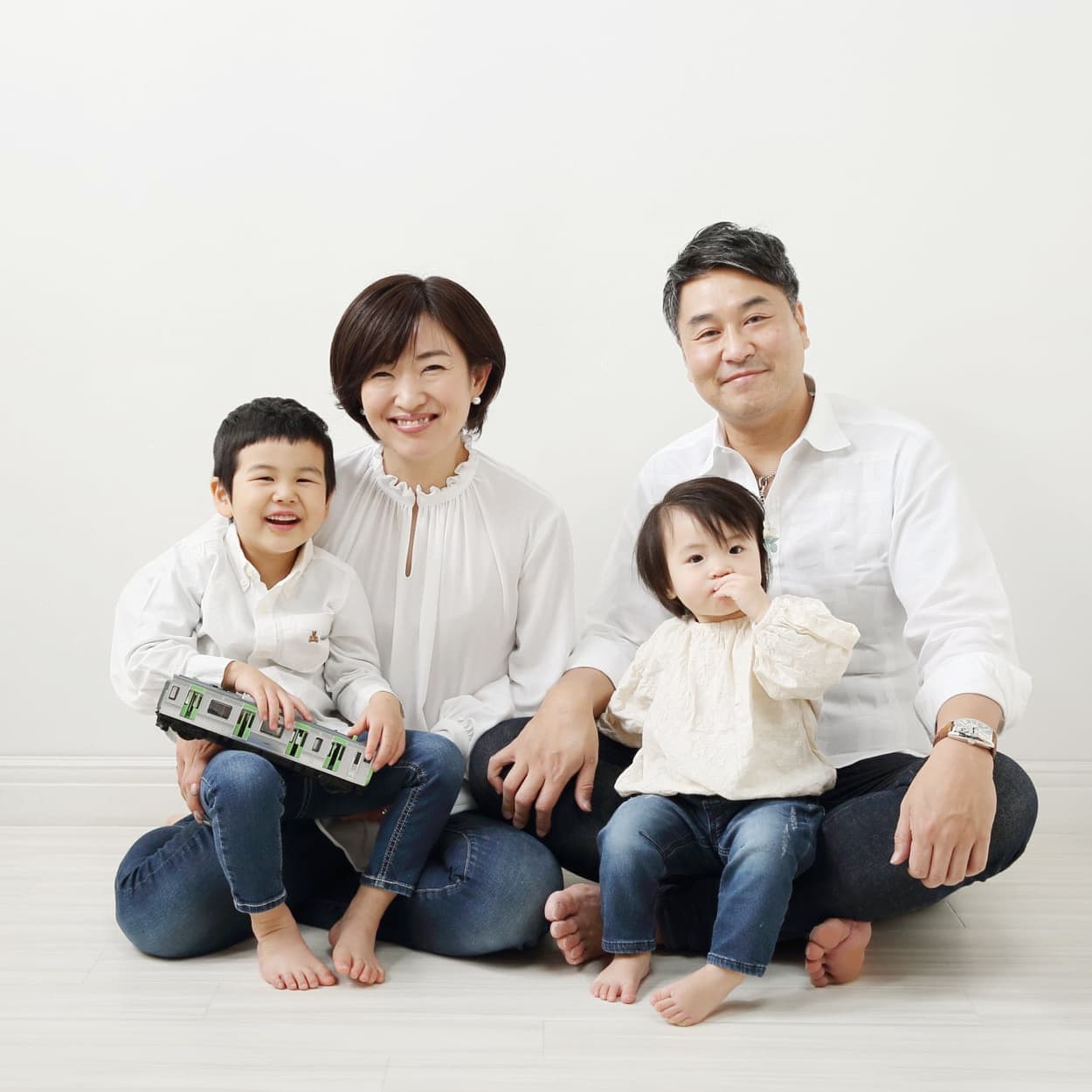 お揃いの白いシャツとデニムで家族写真