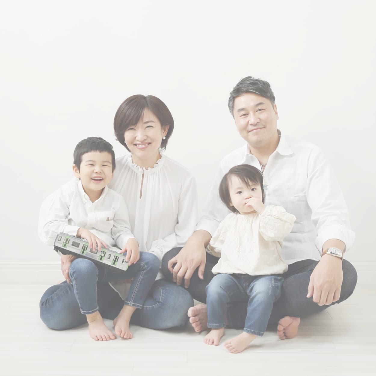 お揃いの白いシャツとデニムで家族写真
